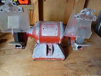 Full view of Baldor bench grinder showing wheels, shields, base and overall condition