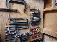 All fifteen C-clamps hanging on board showing sizes and colours
