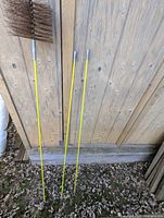 Chimney brush head attached to three yellow extension rods
