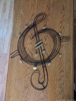 metal treble clef wall sculpture on wood surface