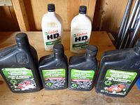 Group shot of all seven oil bottles: five black MotoMaster and two white Castrol.