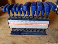 Front view of full 10-piece T-handle hex key set in rack showing size chart