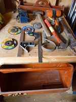 Overall view of assorted hand tools, charger, wooden plane, hammers and toolbox