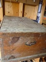Exterior of wooden storage chest showing wear and casters
