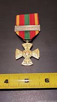 Full view of medal with tape measure for scale