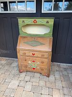 Full view of desk showing drawers, drop-front and attached green cabinet