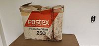 Front view of damaged, stained Fostex Model 250 cardboard box