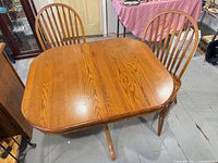Top view of oak pedestal table with two chairs