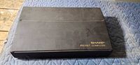 Closed black case with gold Sharp Pocket Computer logo