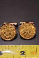 Front view of both coin cufflinks with ruler for scale
