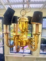 Full view of brass hunt horn chandelier with shades