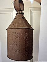 Full view of punched tin light fixture showing hanging loop and conical top