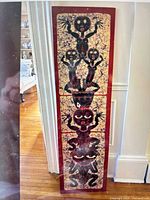 Full view of tall batik fabric artwork leaning against wall