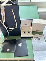 Complete set laid out: shopping bag, cufflinks in open box, outer box, booklets, receipt