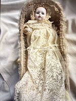 Full view of baby doll in wicker basket