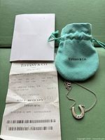 Necklace with pouch, booklet and receipt