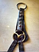 Leather bridle strap showing brass ring, rivets, brass accent