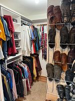 Wide view of closet showing hanging shirts, jackets, shelves and shoe rack