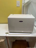 Hard white protective cover on sewing machine base