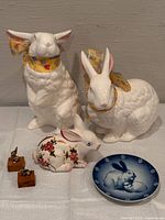 Full lot showing two large white rabbits, floral rabbit, porcelain plate, two mini rabbits