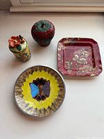 Group shot showing all four items: strawberry dish, trinket box, square plate, butterfly dish