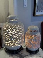 front view of both lit porcelain lamps on bases