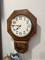Full view of Howard Miller regulator wall clock on wall