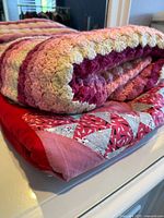 Quilt folded under crochet afghan display of patterns and colors
