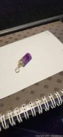 Front view of purple fluorite pendant on notebook