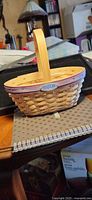 Side view of Longaberger hostess basket with handle and purple rim