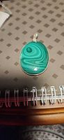Front view of oval malachite cabochon pendant in silver bezel