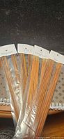 Four incense sleeves fanned out showing scent labels Attraction, Yule, Fire of Love, Sage