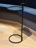 Full view of black iron drinks table showing round top, slender post and circular base