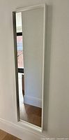 Front view of rectangular full length mirror mounted on wall