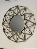 Front view of round brass geometric wall mirror