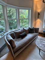 Front angled view of sofa highlighting upholstery, cushions and window backdrop