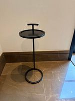 Front view of bronze drink table showing handle, top, stem and base