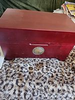 Maroon wooden storage box with National Geographic medallion