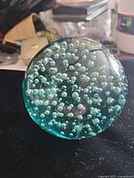 Front view of leaded crystal bubble sphere showing teal tint and internal bubbles