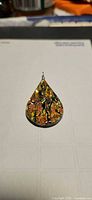 Front view of golden dichroic glass teardrop pendant