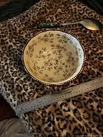 Top view showing interior floral lace pattern and scalloped beaded rim with ruler for scale