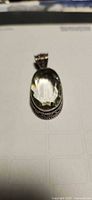 Front view of oval pale green quartz pendant in sterling bezel