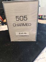 Front view of sealed 505 Charmed perfume box showing name and price sticker