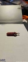 Front view of rhodochrosite crystal point pendant on sheet