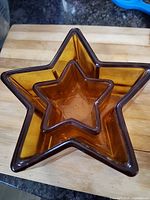 Large and small amber glass star-shaped dishes nested