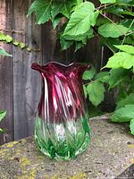 Front view pink and green art glass vase on stone ledge