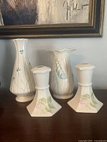 Group shot of all four Belleek pieces: shamrock vase, bluebells vase, two floral candlesticks