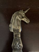 Close-up of unicorn head on brass letter opener handle