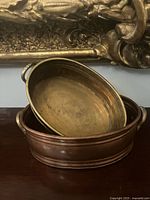 Brass-finish planter resting inside copper-finish planter