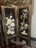 Front view of two panels showing mother-of-pearl floral and bamboo inlay